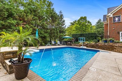 Large in-ground pool with great entertainment space and the beauty of mature trees. | Image 3