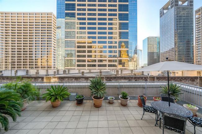 The view standing at top of terrace steps as you exit through the sliding door of home! All pots, plants and furniture on terrace included with sale. Notice you see the reflection of numerous other buildings in the glass facade of the facing building! | Image 20