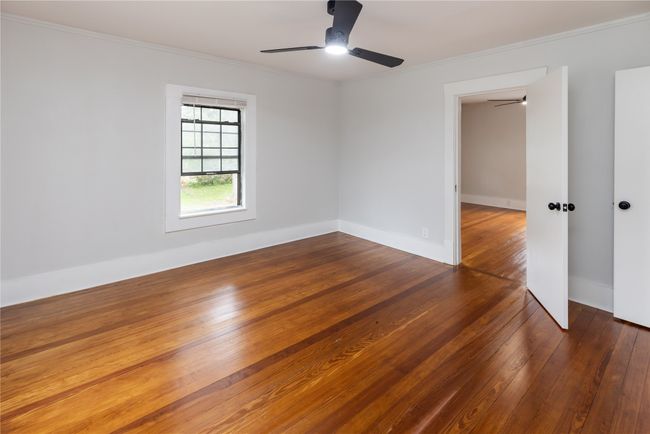 Empty room with ceiling fan, hardwood / wood-style flooring, ornamental molding, and baseboards | Image 21