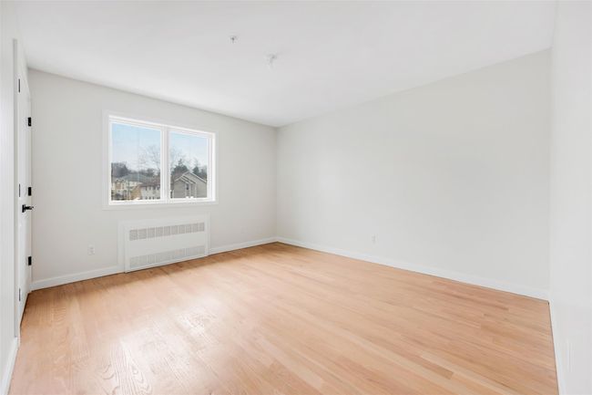 Spare room with light hardwood / wood-style floors and radiator heating unit | Image 39