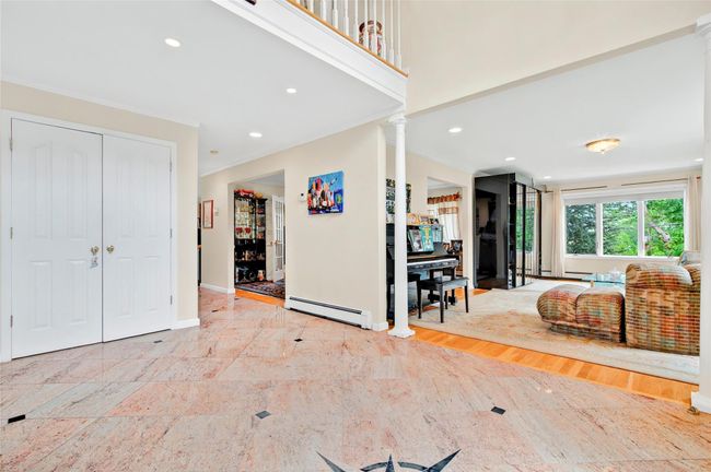 Entrance foyer featuring ornate columns, a baseboard heating unit, ornamental molding, baseboards, and recessed lighting | Image 5
