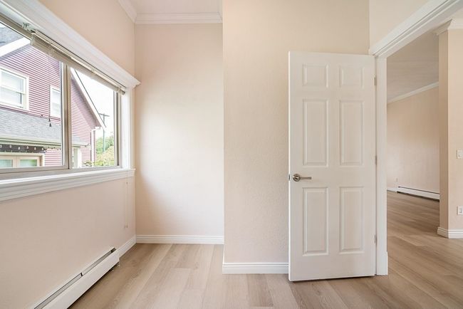 Empty room featuring baseboard heating, ornamental molding, and light wood-style floors | Image 19