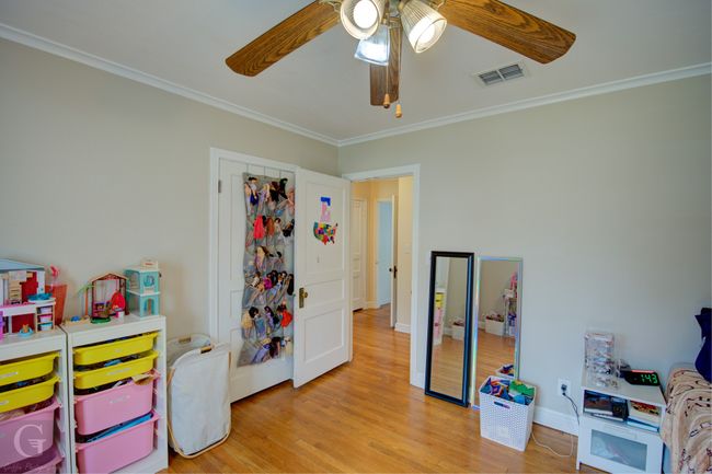 Rec room featuring baseboards, visible vents, ceiling fan, ornamental molding, and wood finished floors | Image 21