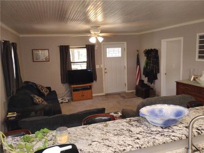 Living room featuring carpet, crown molding, and ceiling fan | Image 3