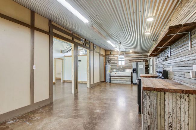 Below grade area with a garage, electric water heater, and stainless steel refrigerator with ice dispenser | Image 25