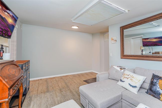Living room with light wood finished floors, baseboards, and visible vents | Image 20