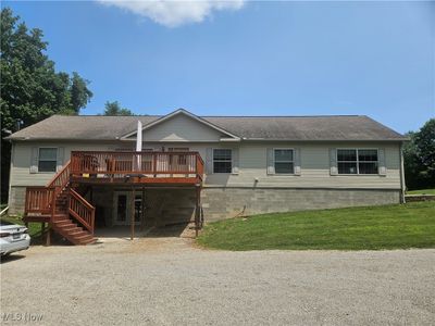 View of front of house with a wooden deck and a front lawn | Image 1