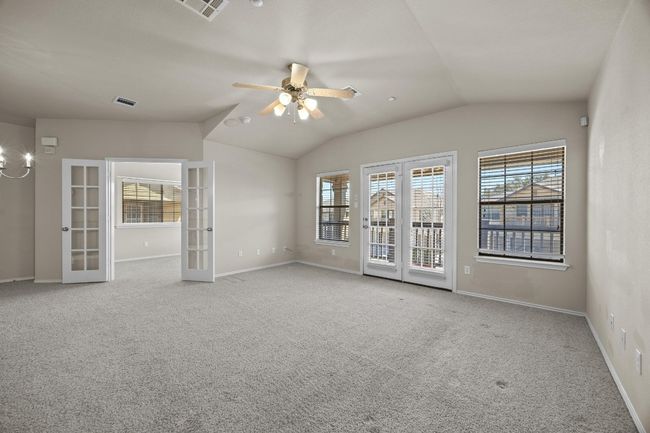 Carpeted spare room featuring lofted ceiling, plenty of natural light, visible vents, and french doors | Image 7