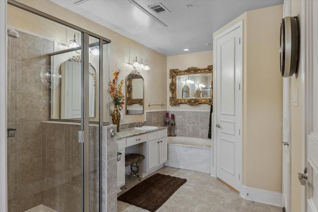 Bathroom with a shower stall, a bath, vanity, and tile patterned flooring | Image 13