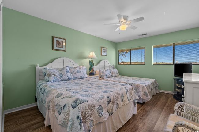 Bedroom with baseboards, visible vents, wood finished floors, and a ceiling fan | Image 26