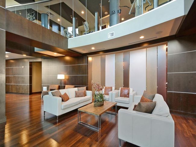 Living area with a high ceiling, visible vents, and wood finished floors | Image 28