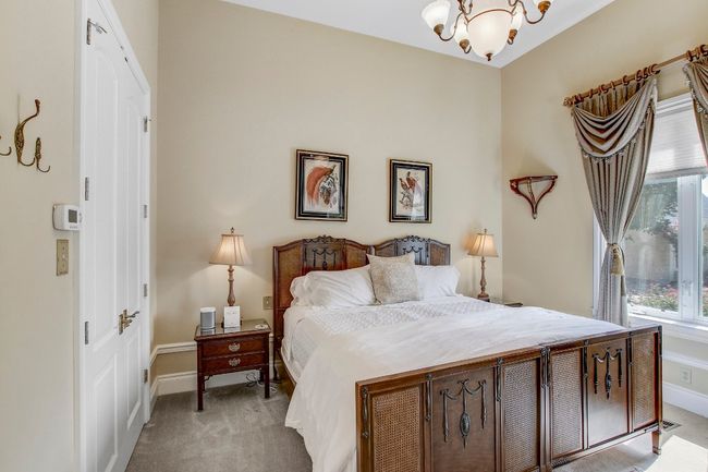 Bedroom with a chandelier, light carpet, and a closet | Image 23