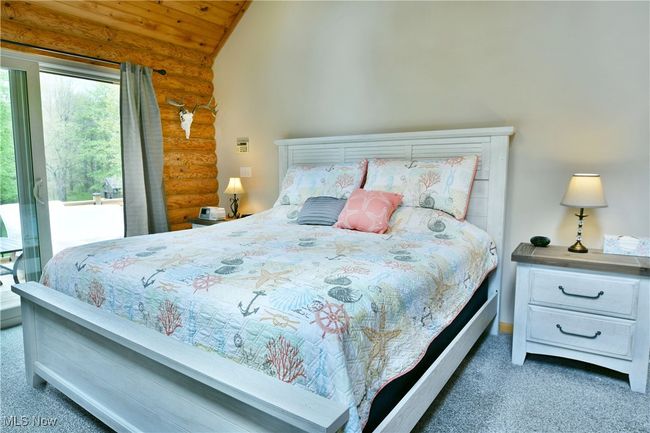 Carpeted bedroom featuring log walls, vaulted ceiling, and wooden ceiling | Image 26