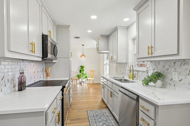 Kitchen featuring stainless steel appliances, a sink, recessed lighting, light wood-style flooring, and tasteful backsplash | Image 8