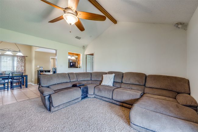 Living room featuring a ceiling fan, light tile patterned flooring, and light colored carpet | Image 4