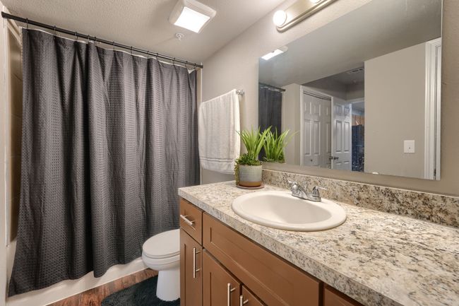 Bathroom featuring toilet, wood finished floors, vanity, and shower / bath combination with curtain | Image 13