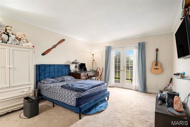 Bedroom with light carpet, a textured ceiling, access to outside, crown molding, and an office area | Image 10