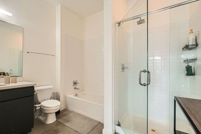 Bathroom with a shower with door, toilet, a bathtub, and vanity | Image 15