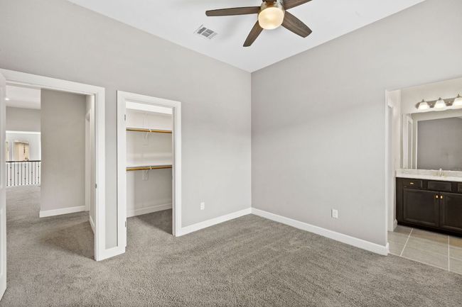 Unfurnished bedroom featuring a sink, a spacious closet, baseboards, and light carpet | Image 32