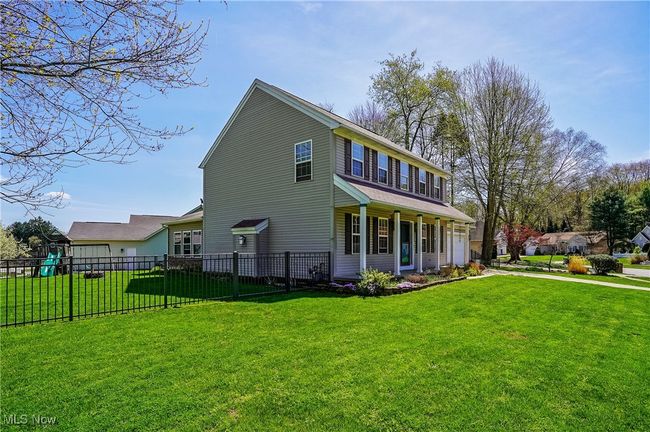 View of home's exterior with a lawn, covered porch, and fence | Image 45