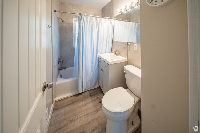Full bathroom with wood finished floors, shower / bath combo with shower curtain, and vanity | Image 14