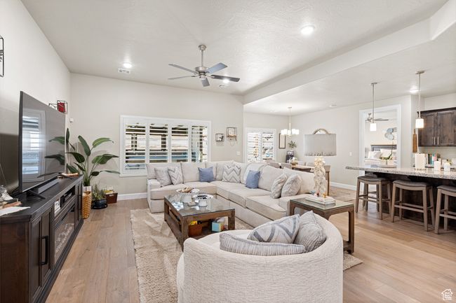 Living area featuring ceiling fan, light wood-style flooring, a chandelier, and recessed lighting | Image 54