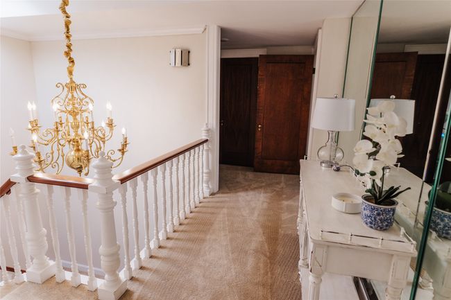 Corridor with an inviting chandelier, crown molding, and light colored carpet | Image 25