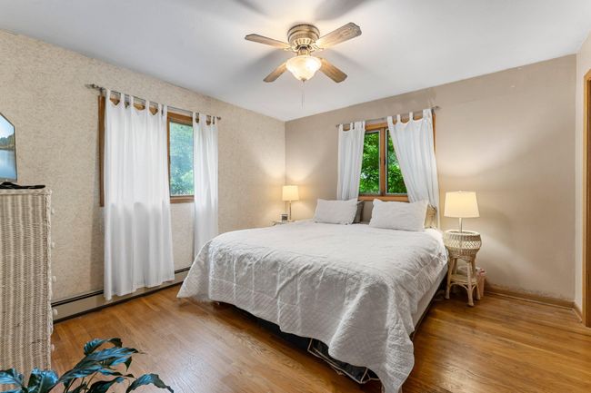 Two comfortable bedrooms are located on the main level—one with hardwood floors, the other carpeted for added coziness. | Image 6