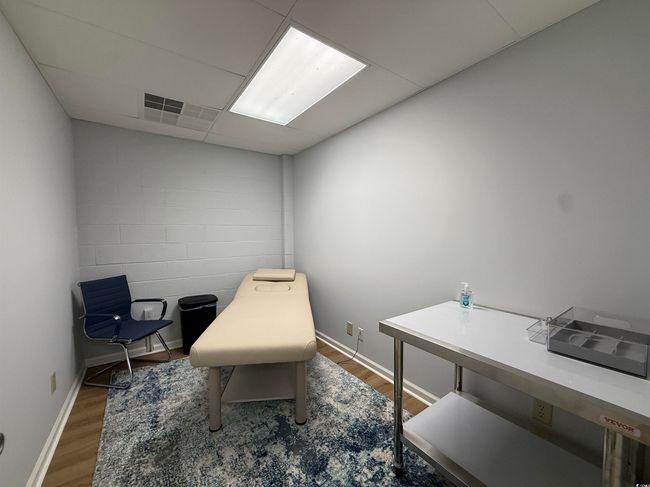 Office featuring wood finished floors and concrete block wall | Image 7