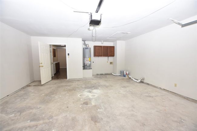 This well-maintained garage offers a practical and organized space, featuring dedicated hookups for a washer and dryer | Image 30