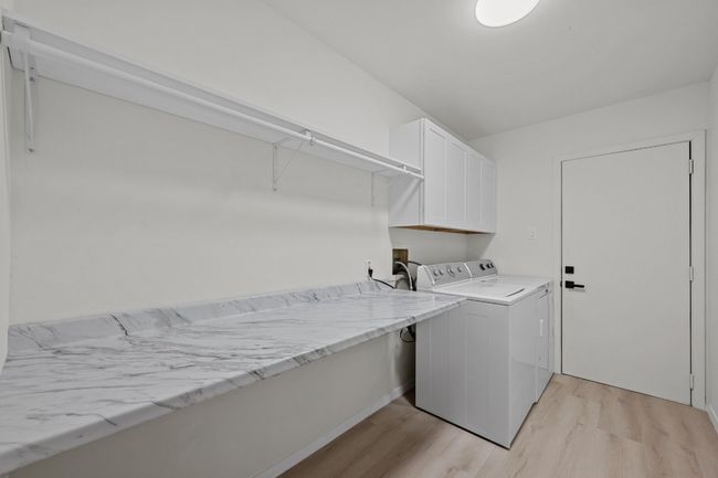 Laundry room with washer and dryer, light wood-style flooring, and cabinet space | Image 17