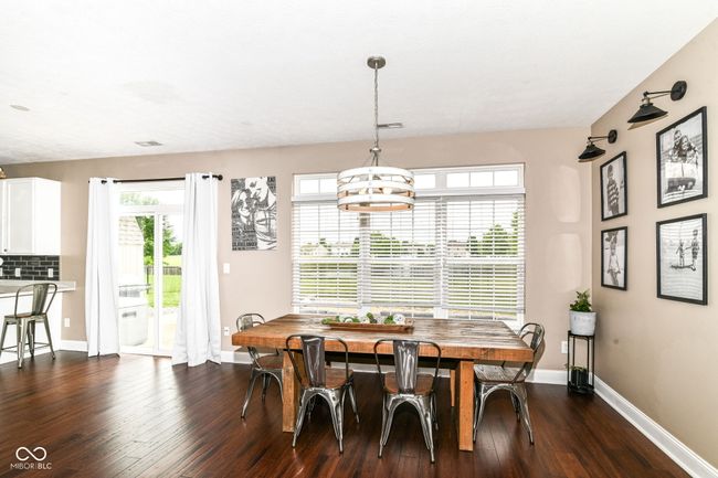 dining area featuring dark wood-style flooring and baseboards | Image 5