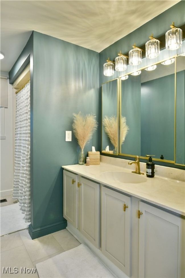 Full bath featuring tile patterned floors, a shower with curtain, vanity, and baseboards | Image 33