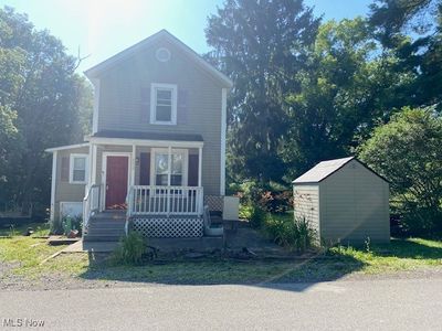 Front facade featuring covered porch and a storage unit | Image 1