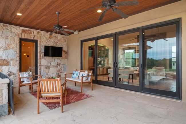 View of patio / terrace with a ceiling fan, expansive sliders, and an outdoor living space. | Image 23