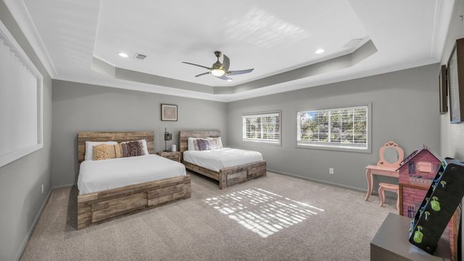 Bedroom with a tray ceiling, carpet floors, recessed lighting, ceiling fan, and ornamental molding | Image 26