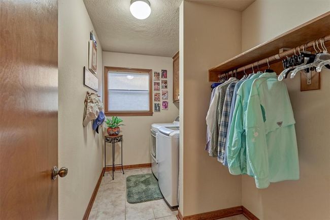 The spacious first-floor laundry room is thoughtfully designed with hanging space and closed storage, combining function and convenience. | Image 35