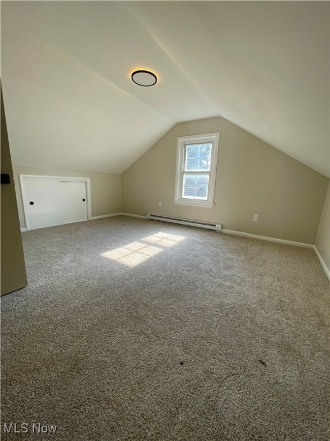 Bonus room with a baseboard radiator, lofted ceiling, and carpet flooring | Image 24