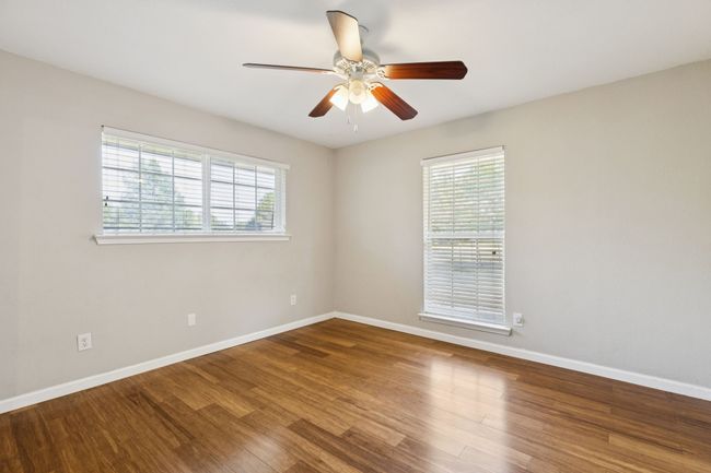 Empty room with plenty of natural light, ceiling fan, and wood finished floors | Image 14