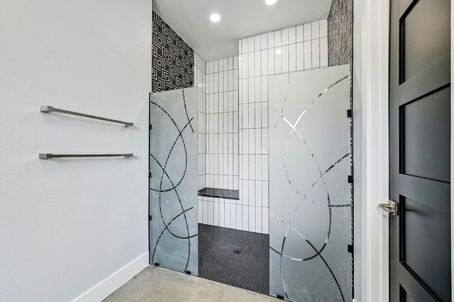 Amazing spa-inspired two person walk-in shower with custom frameless glass, two shower heads, designer backsplash, and bench seating. | Image 22