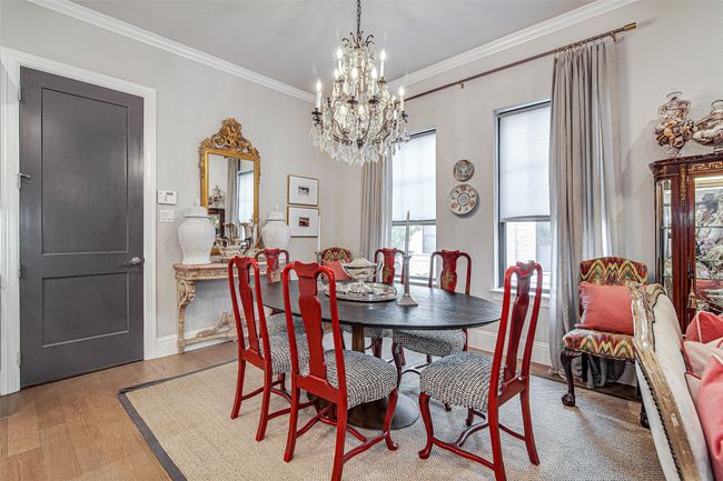 Dining space with crown molding, light wood-style flooring, an inviting chandelier, and baseboards | Image 9