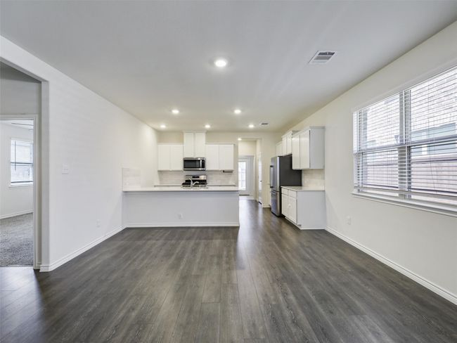 Unfurnished living room with dark wood-style flooring and recessed lighting | Image 7
