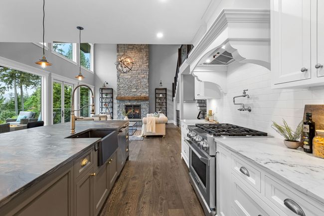 Kitchen with appliances with stainless steel finishes, a sink, white cabinets, dark wood-style flooring, and backsplash | Image 13