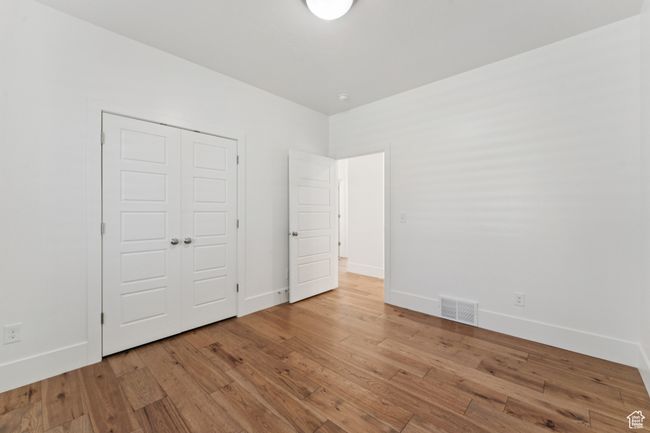 Unfurnished bedroom featuring wood-type flooring and a closet | Image 18
