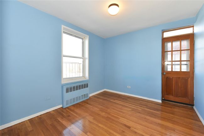 Empty room featuring hardwood / wood-style floors and radiator heating unit | Image 17