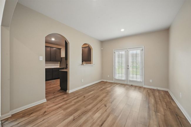 Unfurnished living room with arched walkways, recessed lighting, light wood-type flooring, and baseboards | Image 10