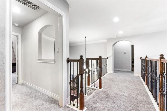 From the main staircase, the view showcases the junior en suite, as well as the catwalk leading to two guest bedrooms that share a Hollywood-style bathroom. The open design creates a sense of space and connectivity, offering both privacy for the bedrooms and easy access to the shared bathroom. | Image 31