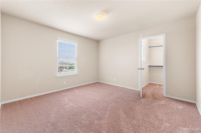 Unfurnished bedroom featuring carpet, a walk in closet, and a closet | Image 26
