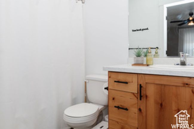 Bathroom featuring toilet, vanity, and curtained shower | Image 22