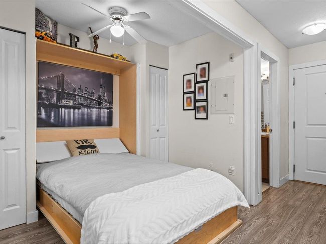 Bedroom featuring wood finished floors, a closet, a ceiling fan, and electric panel | Image 11